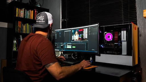 A man using video editing software on his monitor.